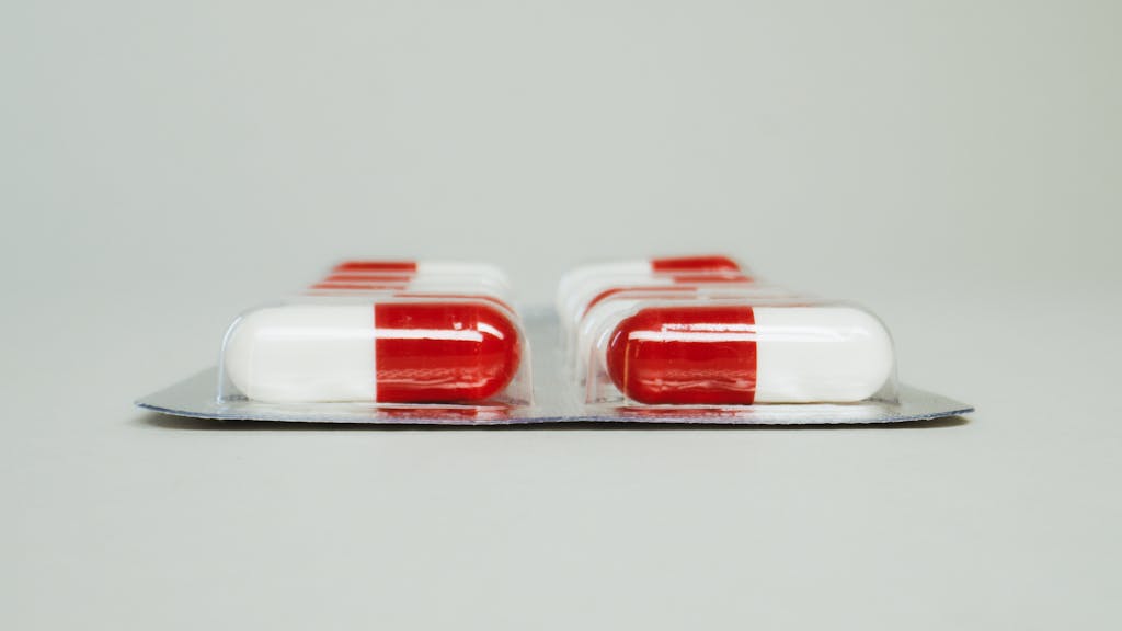 Blister pack of red and white capsules isolated against a simple background.